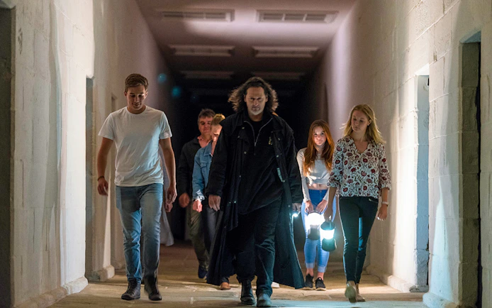 Group walking through a dimly lit corridor on Port Arthur Historic Site Ghost Tour.