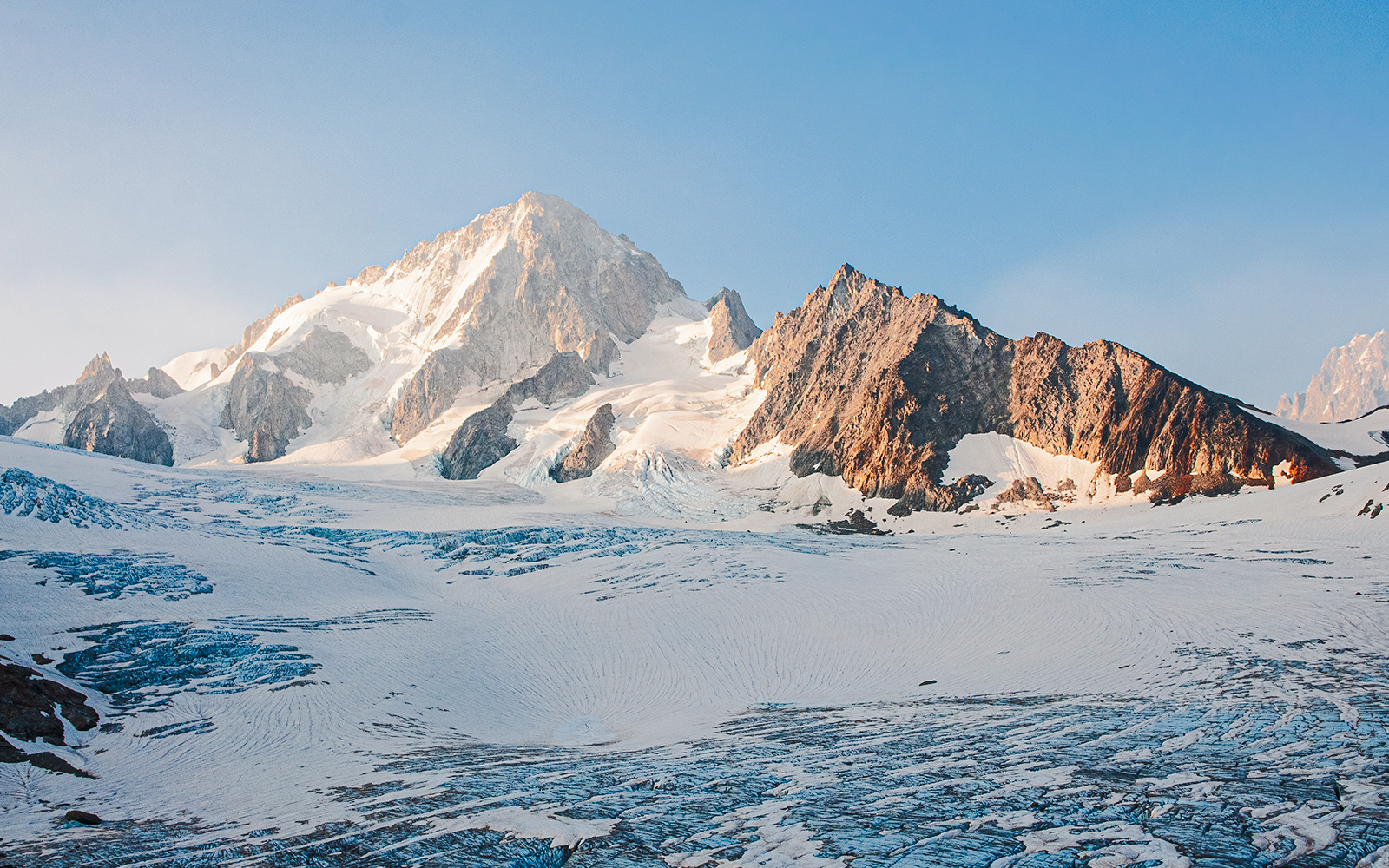 Snow-covered Mont Blanc massif in the French Alps under a clear blue sky.