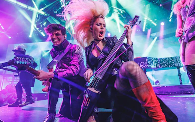 Musicians performing energetically on stage with vibrant lighting at WAH event.