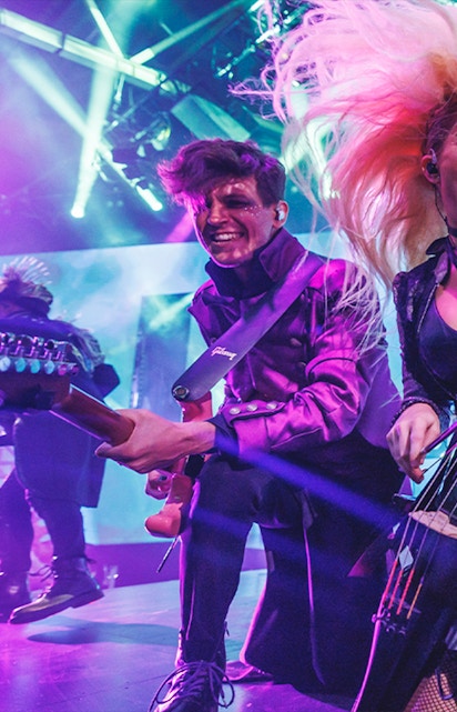 Musicians performing energetically on stage with vibrant lighting at WAH event.