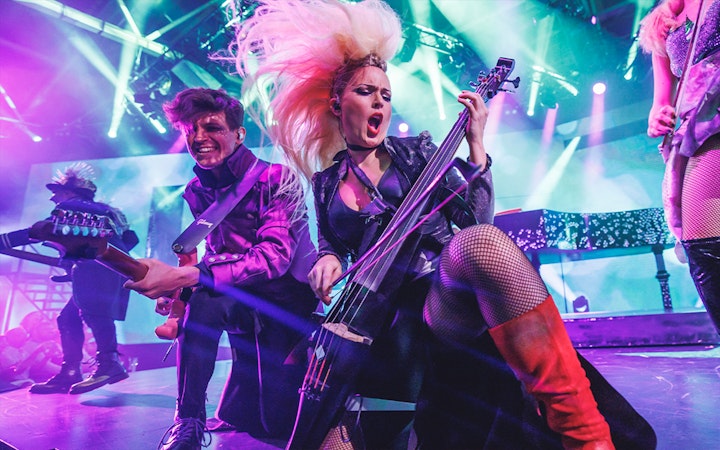 Musicians performing energetically on stage with vibrant lighting at WAH event.