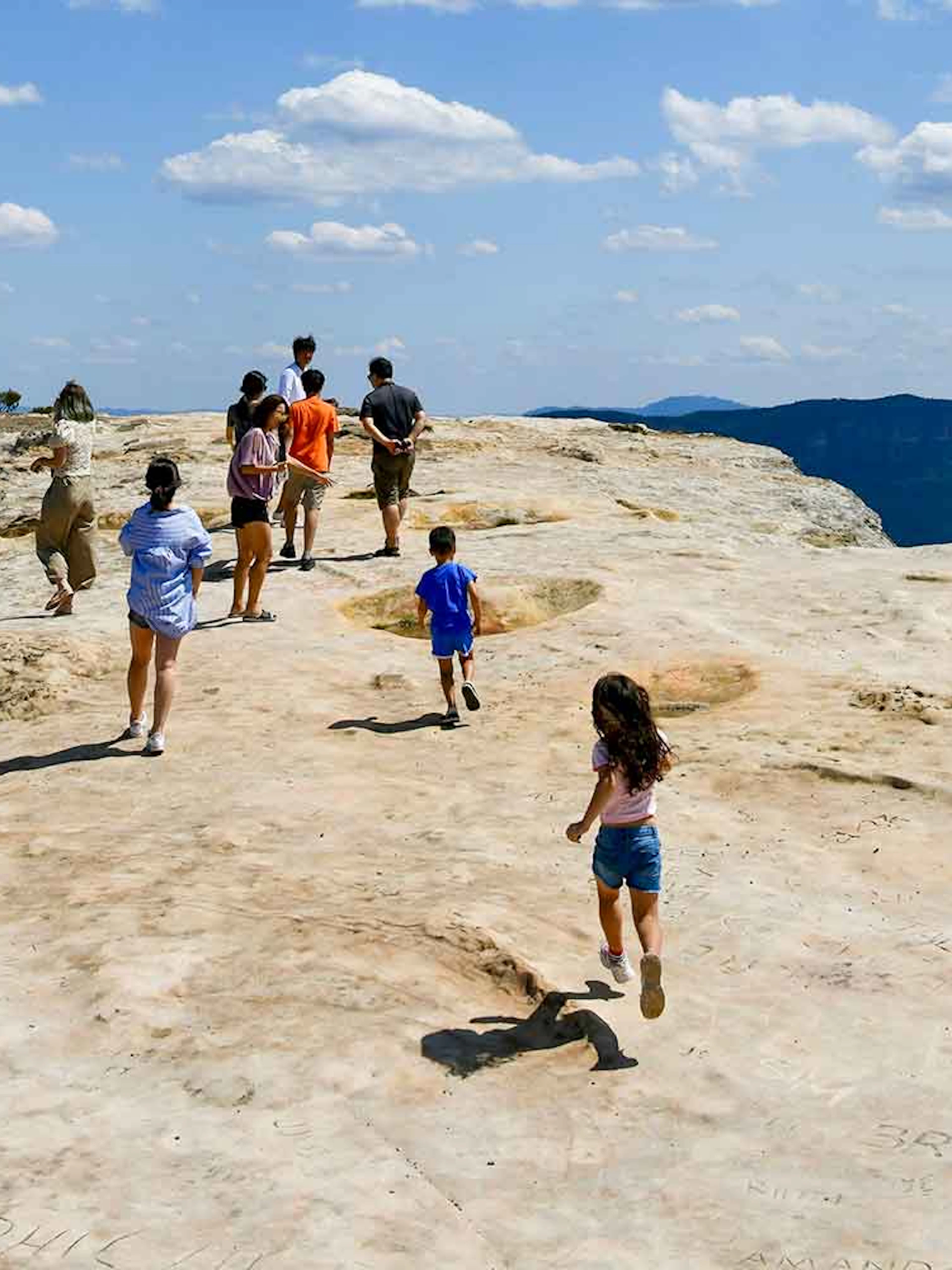 People walking on Lincoln's Rock at Wentworth Falls with scenic views.