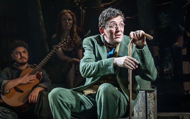Actor in green suit with cane on stage during "The Curious Case of Benjamin Button - The Musical.