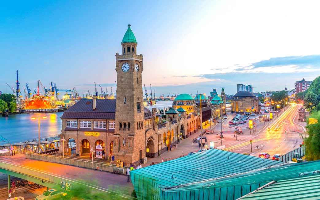 Hamburg harbor view with historic clock tower and bustling waterfront.