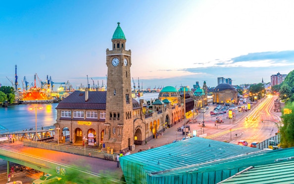 Hamburg harbor view with historic clock tower and bustling waterfront.