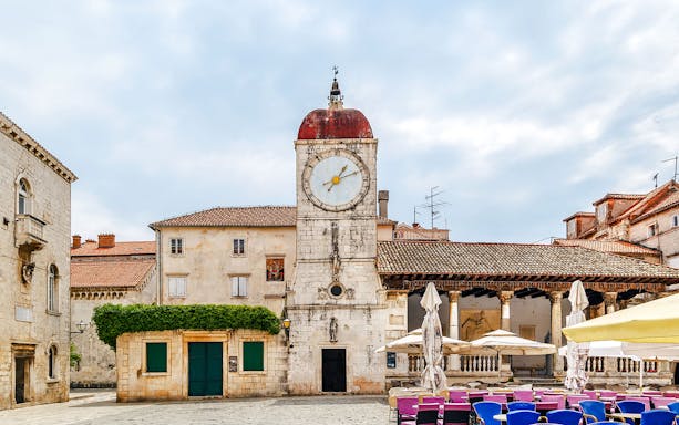 Loggia and clock tower in Trogir, Croatia, with surrounding historic buildings.