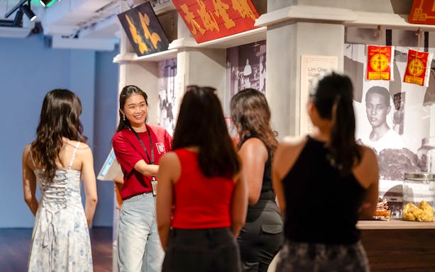 Guide leading visitors at Chinatown Heritage Centre exhibit.