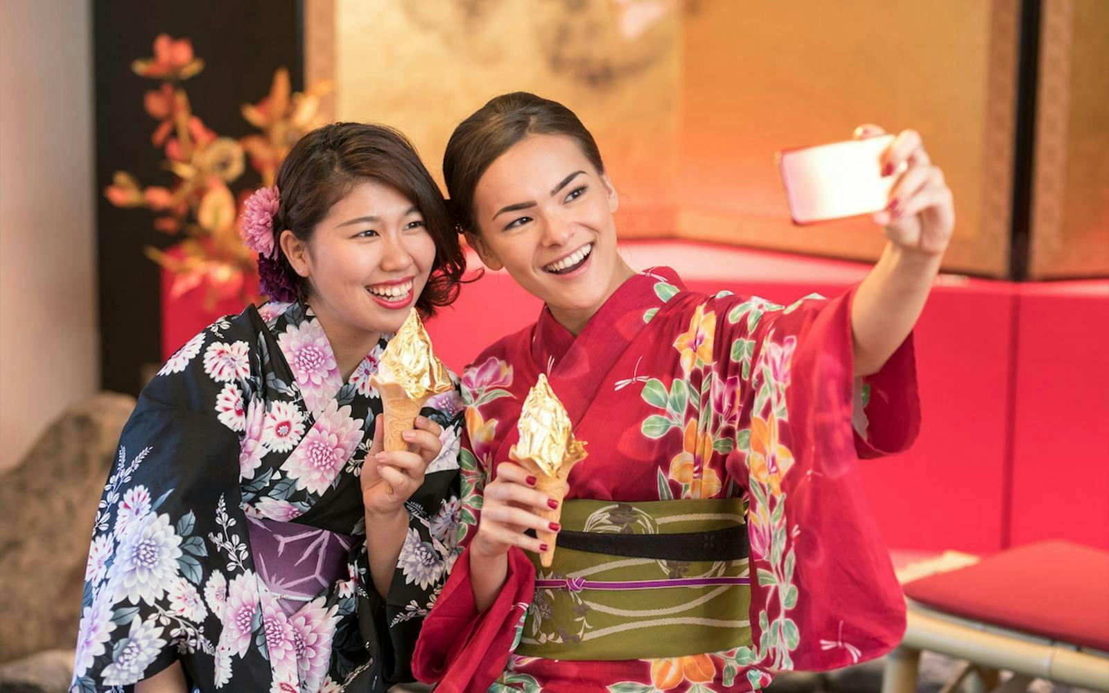 Women in kimonos enjoying gold leaf ice cream on Shirakawa-go Day Tour from Kanazawa.