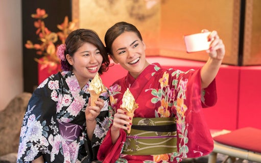 Women in kimonos enjoying gold leaf ice cream on Shirakawa-go Day Tour from Kanazawa.