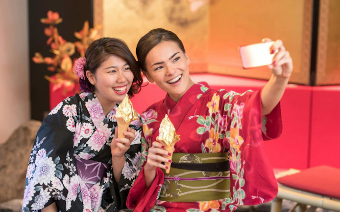 Women in kimonos enjoying gold leaf ice cream on Shirakawa-go Day Tour from Kanazawa.