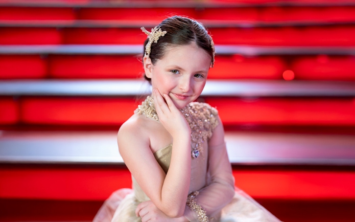 Girl posing on red stairs at Times Square Tkts, New York City.