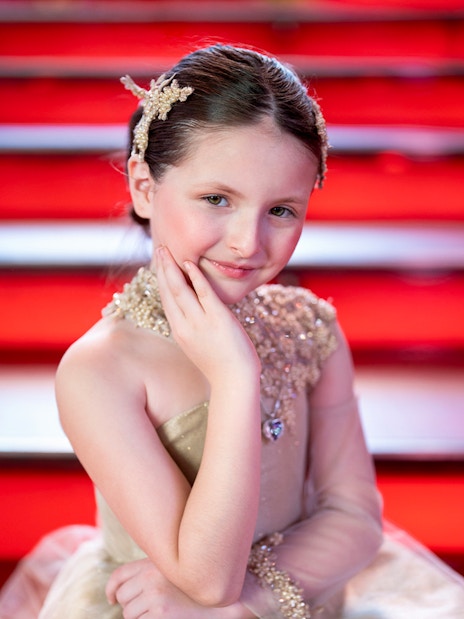 Girl posing on red stairs at Times Square Tkts, New York City.