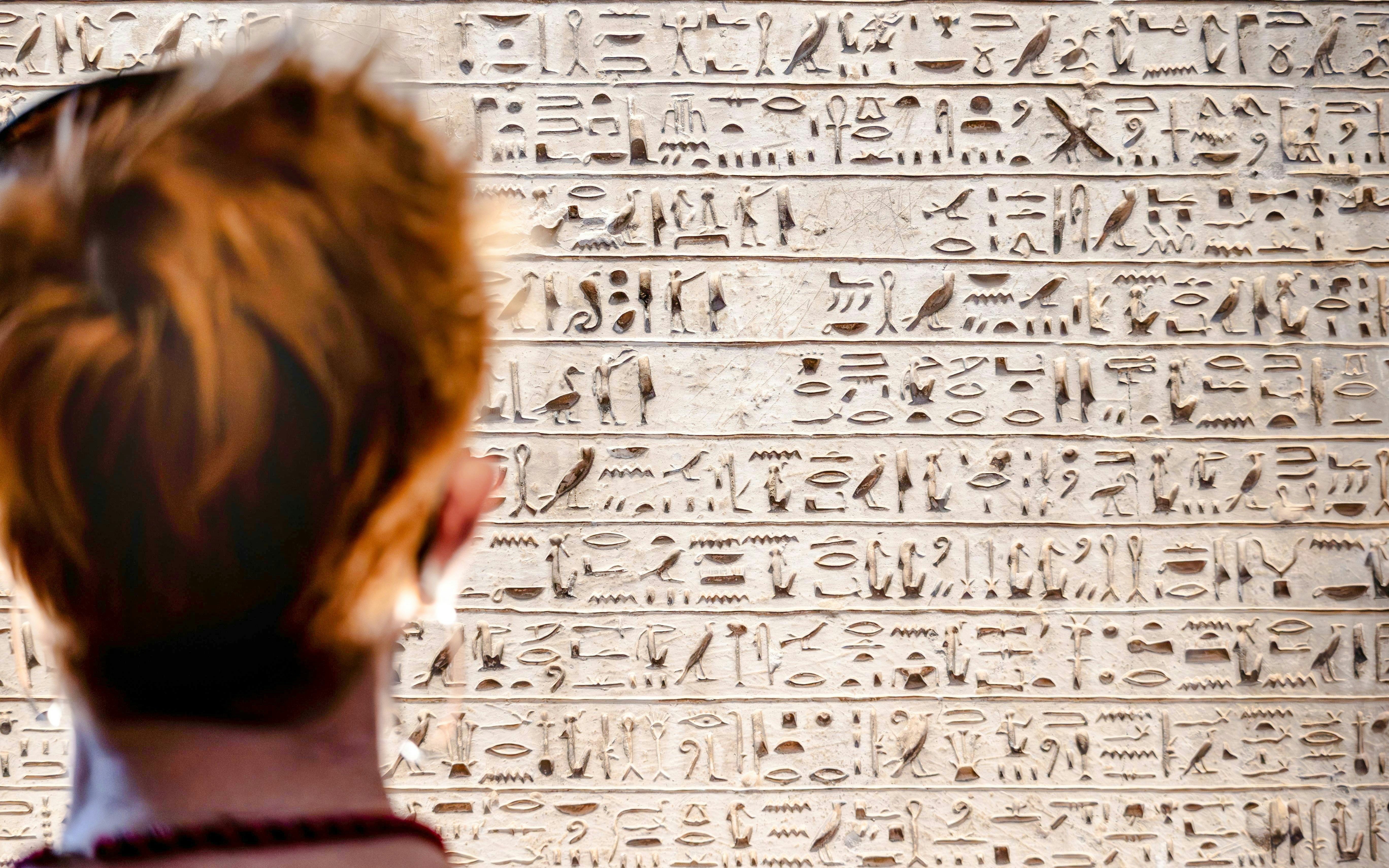 Visitor observing hieroglyphs at Temple of Ellesiya.