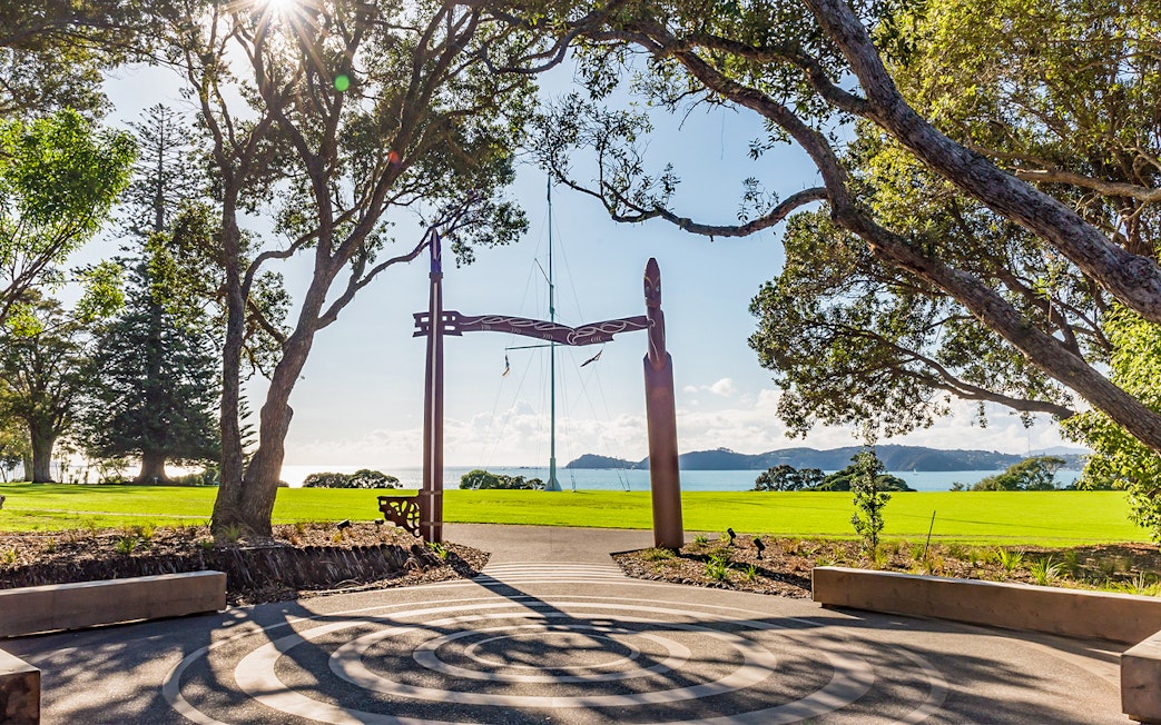 View from Te Rau Aroha with carved wooden archway and ocean in the background.
