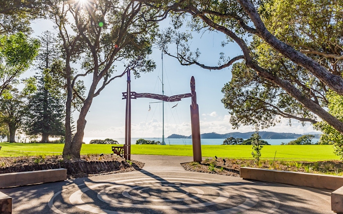 View from Te Rau Aroha with carved wooden archway and ocean in the background.