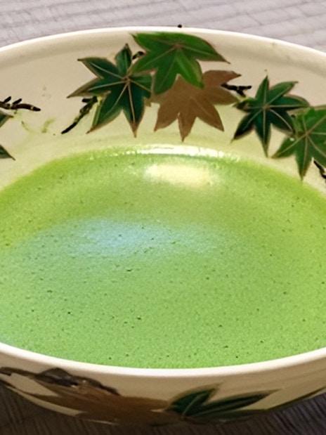 Ceramic bowl with matcha tea and leaf design, Kyoto tea ceremony.