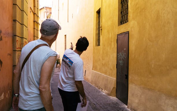 Tour guide leading a food tour through a narrow street in Bologna.
