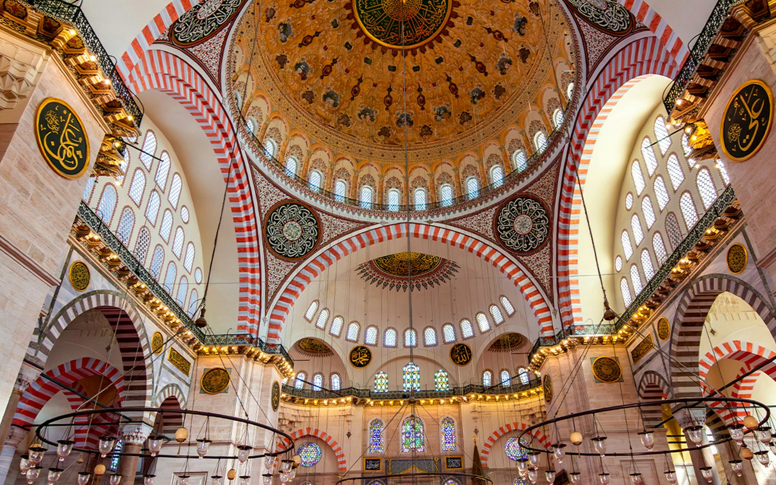 Dome ceiling interior of Süleymaniye Mosque with intricate patterns and arches.