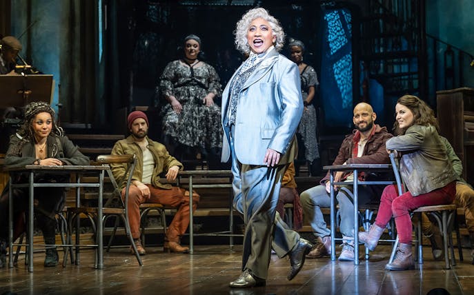 Cast performing on stage in Hadestown musical.