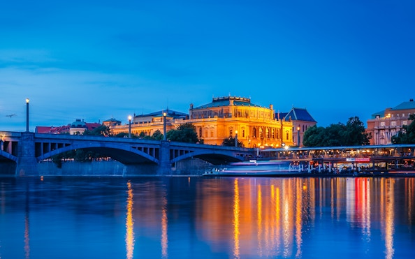 Rudolfinum illuminated at night by the Vltava River, Prague, Czech Republic.