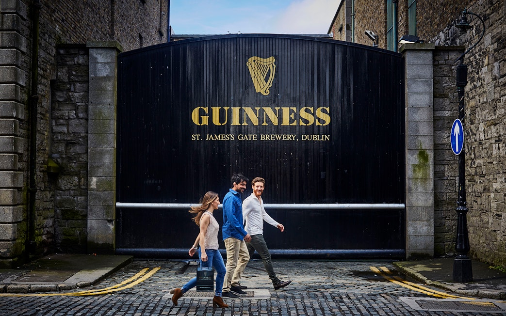 Visitors walking past the Guinness Storehouse gate in Dublin, Ireland.