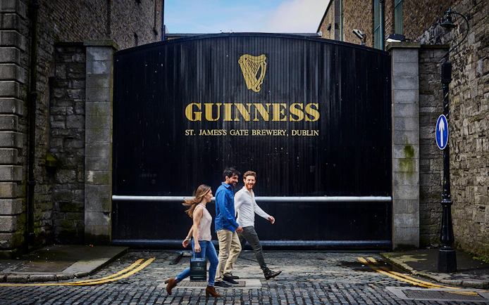Visitors walking past the Guinness Storehouse gate in Dublin, Ireland.
