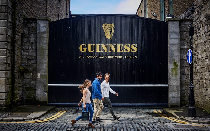 Visitors walking past the Guinness Storehouse gate in Dublin, Ireland.