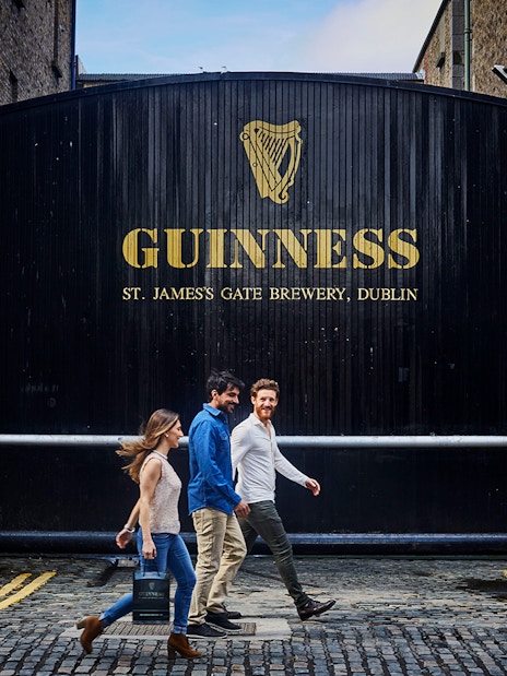 Visitors walking past the Guinness Storehouse gate in Dublin, Ireland.