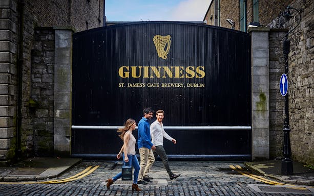Visitors walking past the Guinness Storehouse gate in Dublin, Ireland.