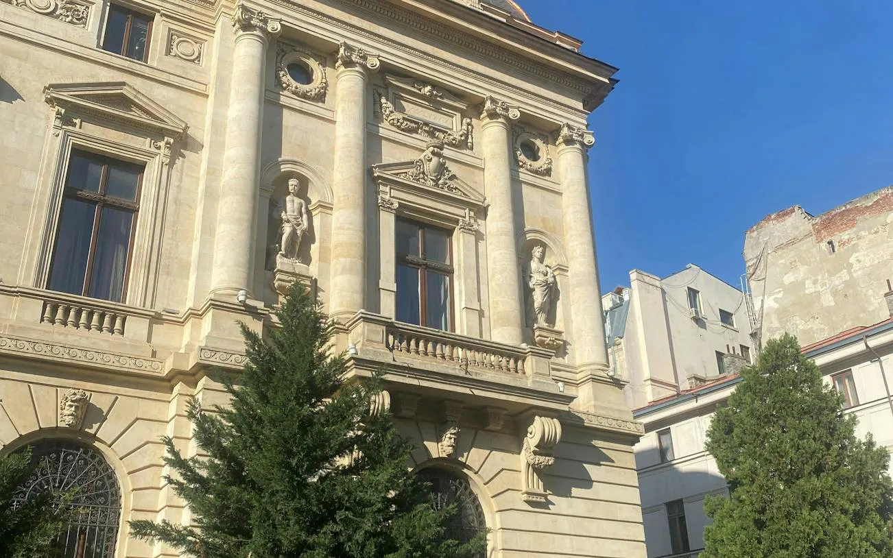 Historic building facade with statues in Bucharest, part of the self-guided city exploration game.