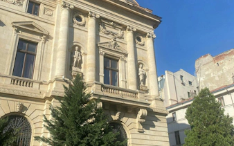 Historic building facade with statues in Bucharest, part of the self-guided city exploration game.