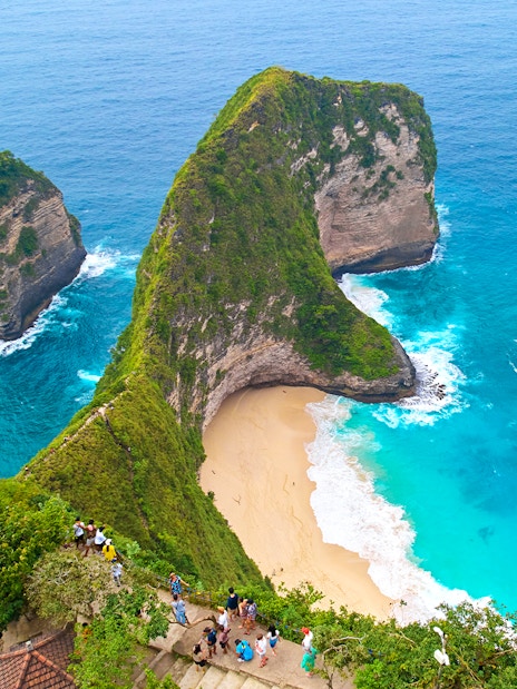Tourists enjoying the view of Kelingking Beach, West Nusa Penida Island, Indonesia.