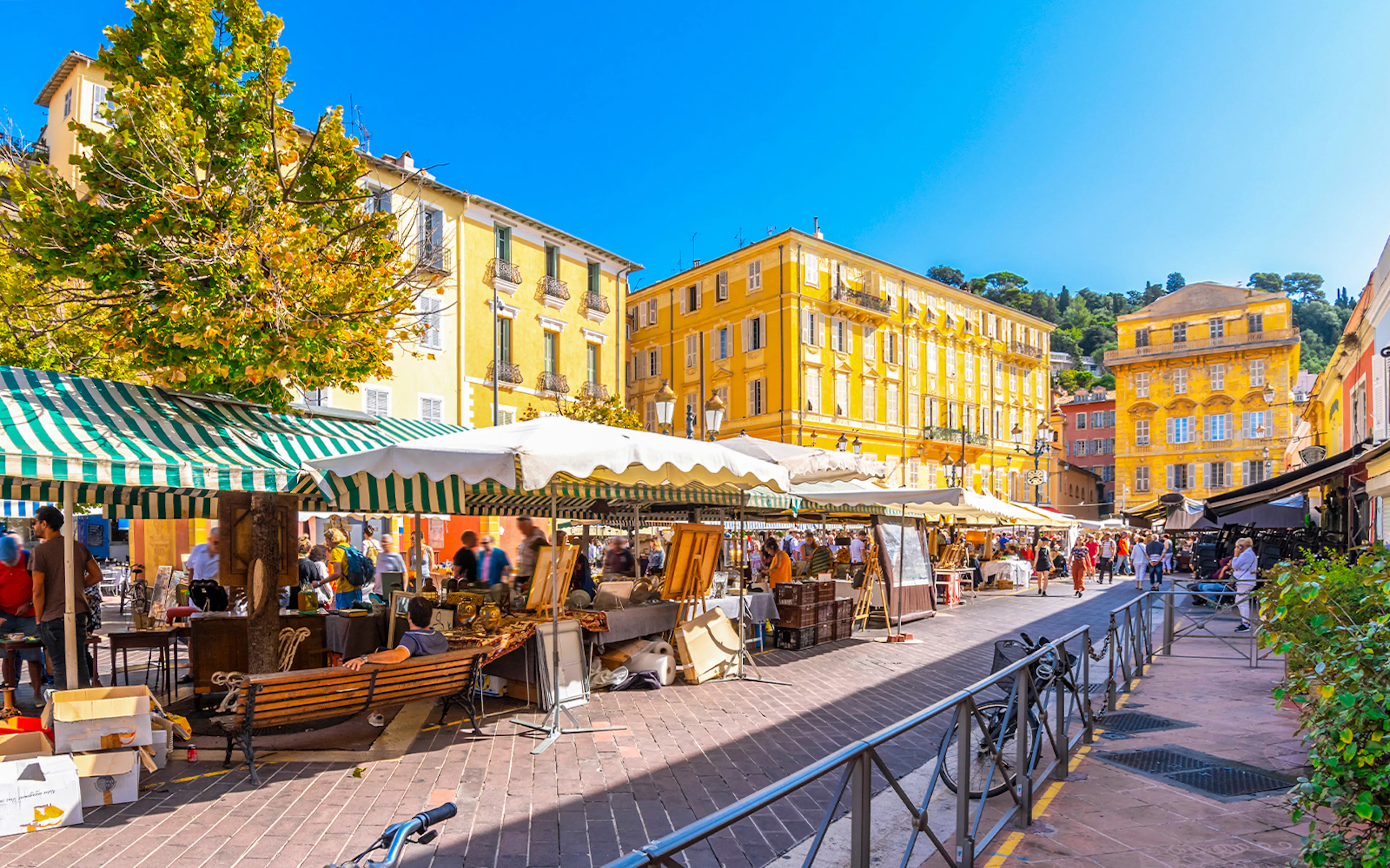 Cours Saleya market stalls with people browsing in Nice, France.
