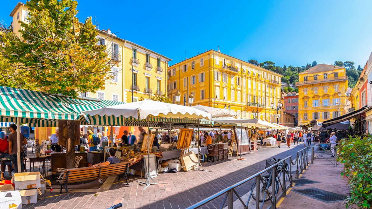 Cours Saleya market stalls with people browsing in Nice, France.