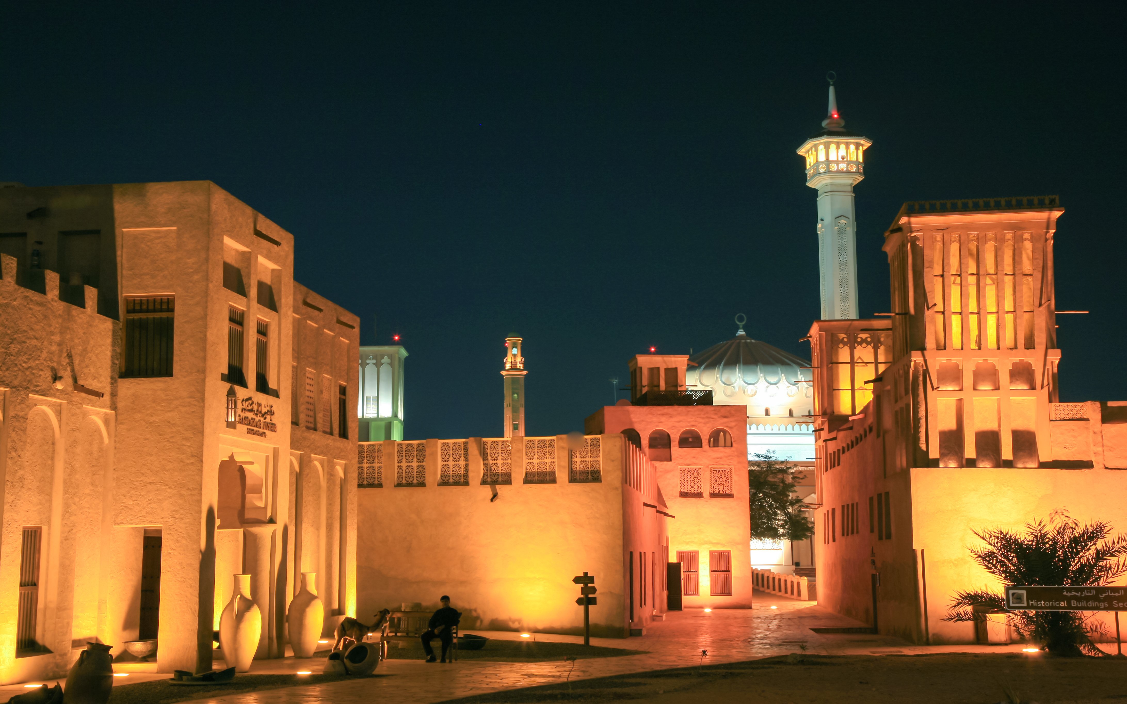Fahidi Historical Neighbourhood in Dubai illuminated at night with traditional wind towers.
