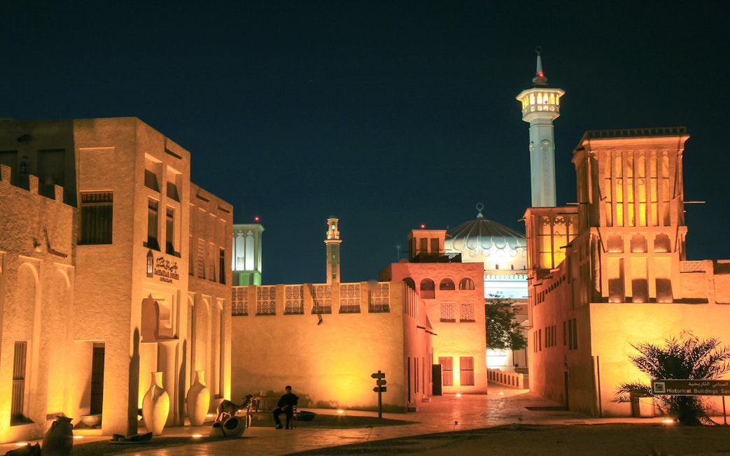 Fahidi Historical Neighbourhood in Dubai illuminated at night with traditional wind towers.