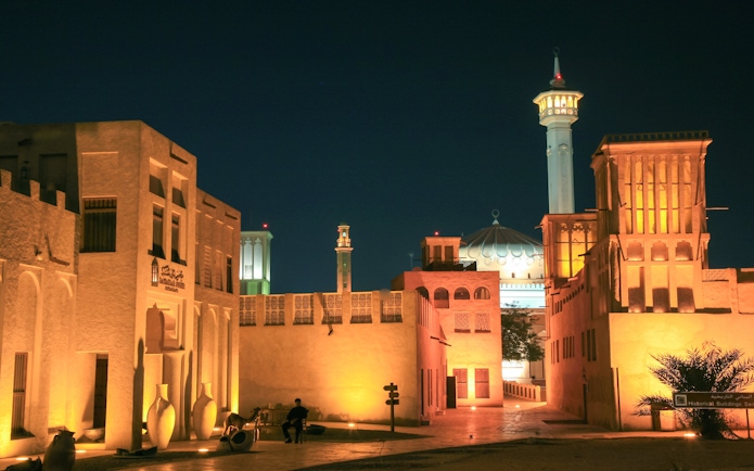 Fahidi Historical Neighbourhood in Dubai illuminated at night with traditional wind towers.