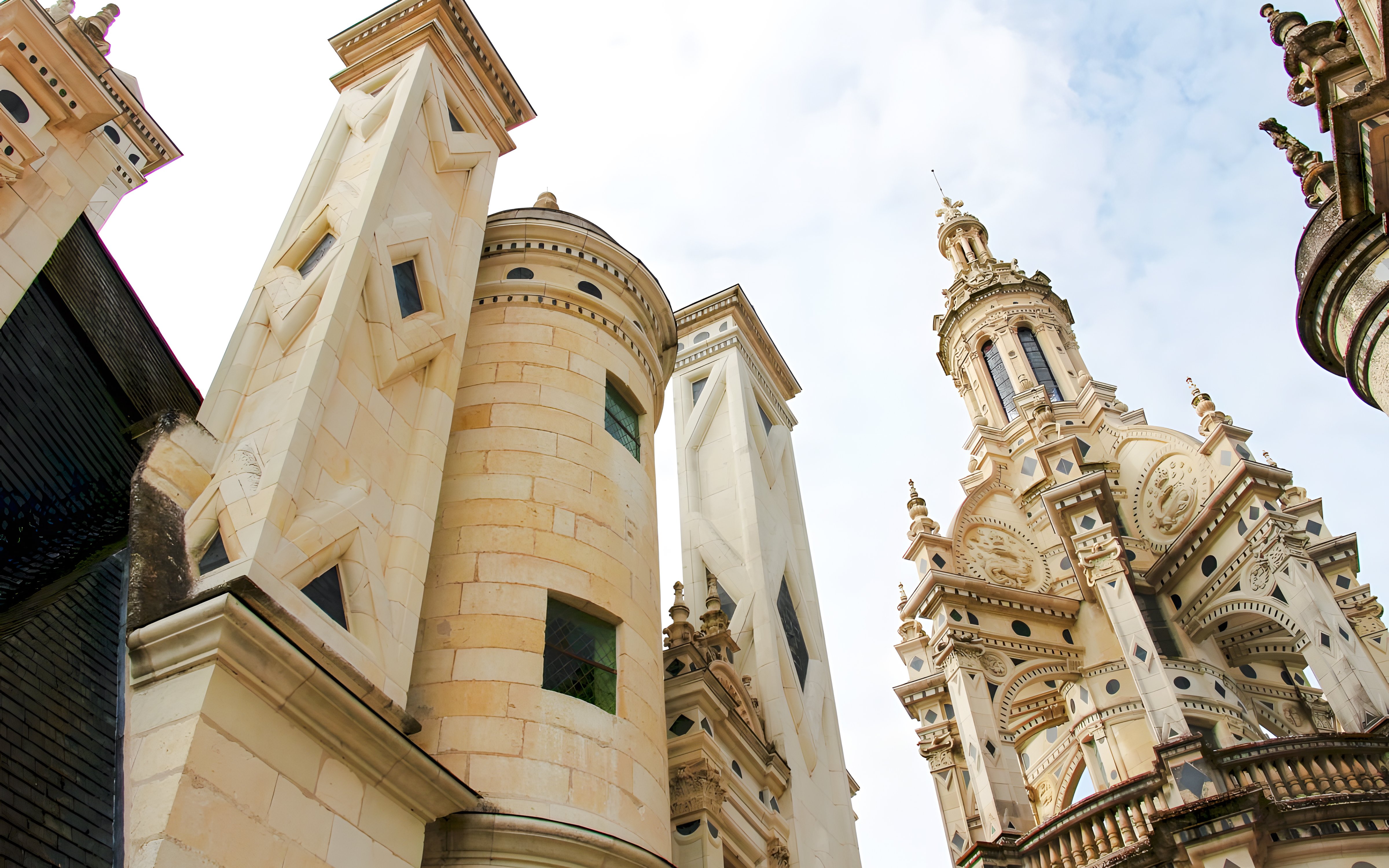 Chambord Castle towers and ornate spire against a blue sky in France.