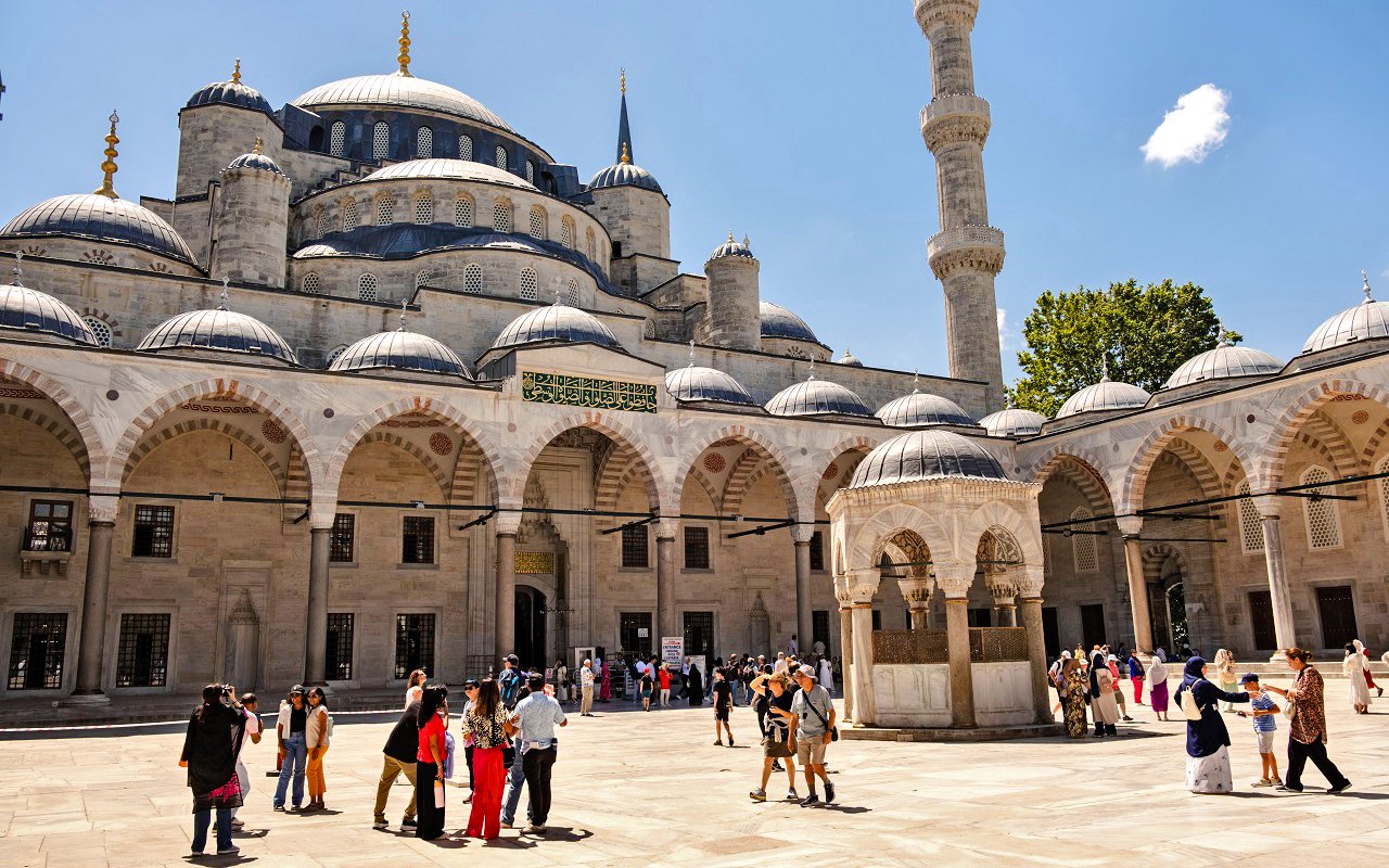 Courtyard of Hagia Sophia with visitors exploring the historic architecture in Istanbul.