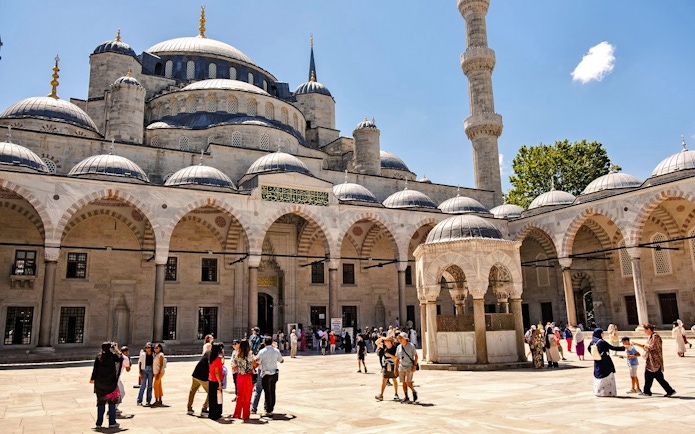 Courtyard of Hagia Sophia with visitors exploring the historic architecture in Istanbul.