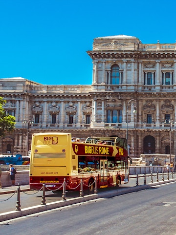 Big Bus Rome tour passing by historic building in Rome, Italy.