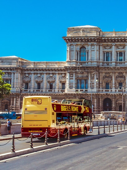 Big Bus Rome tour passing by historic building in Rome, Italy.
