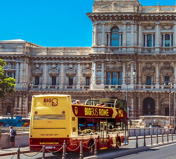 Big Bus Rome tour passing by historic building in Rome, Italy.