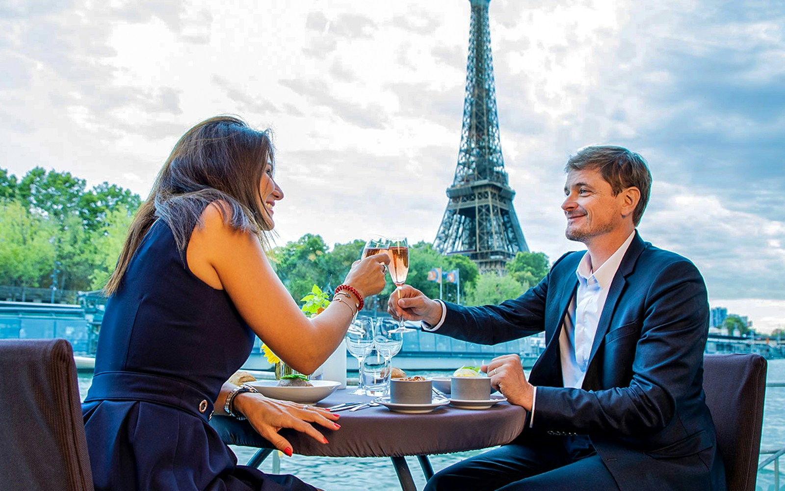 Couple toasting on a Paris New Year’s Eve 2025 cruise with Eiffel Tower view.