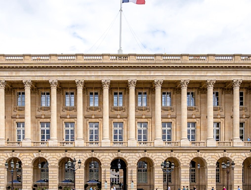 Hôtel de la Marine facade with French flag in Paris, France.