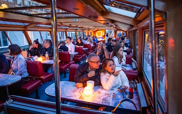 Guests enjoying the Happy Valentine Evening Cruise in a cozy, candlelit boat setting.