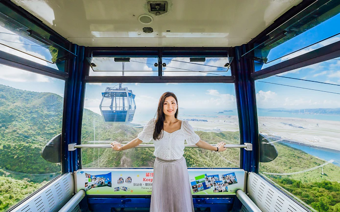 Standard cable car interior at Ngong Ping 360, Hong Kong with scenic mountain and sea views.