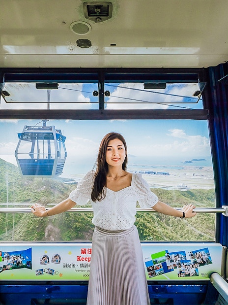 Standard cable car interior at Ngong Ping 360, Hong Kong with scenic mountain and sea views.