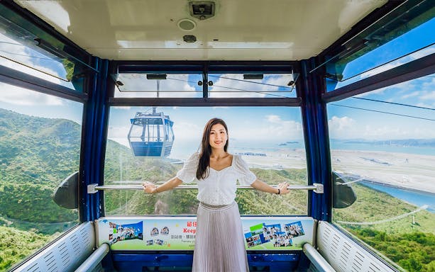 Standard cable car interior at Ngong Ping 360, Hong Kong with scenic mountain and sea views.