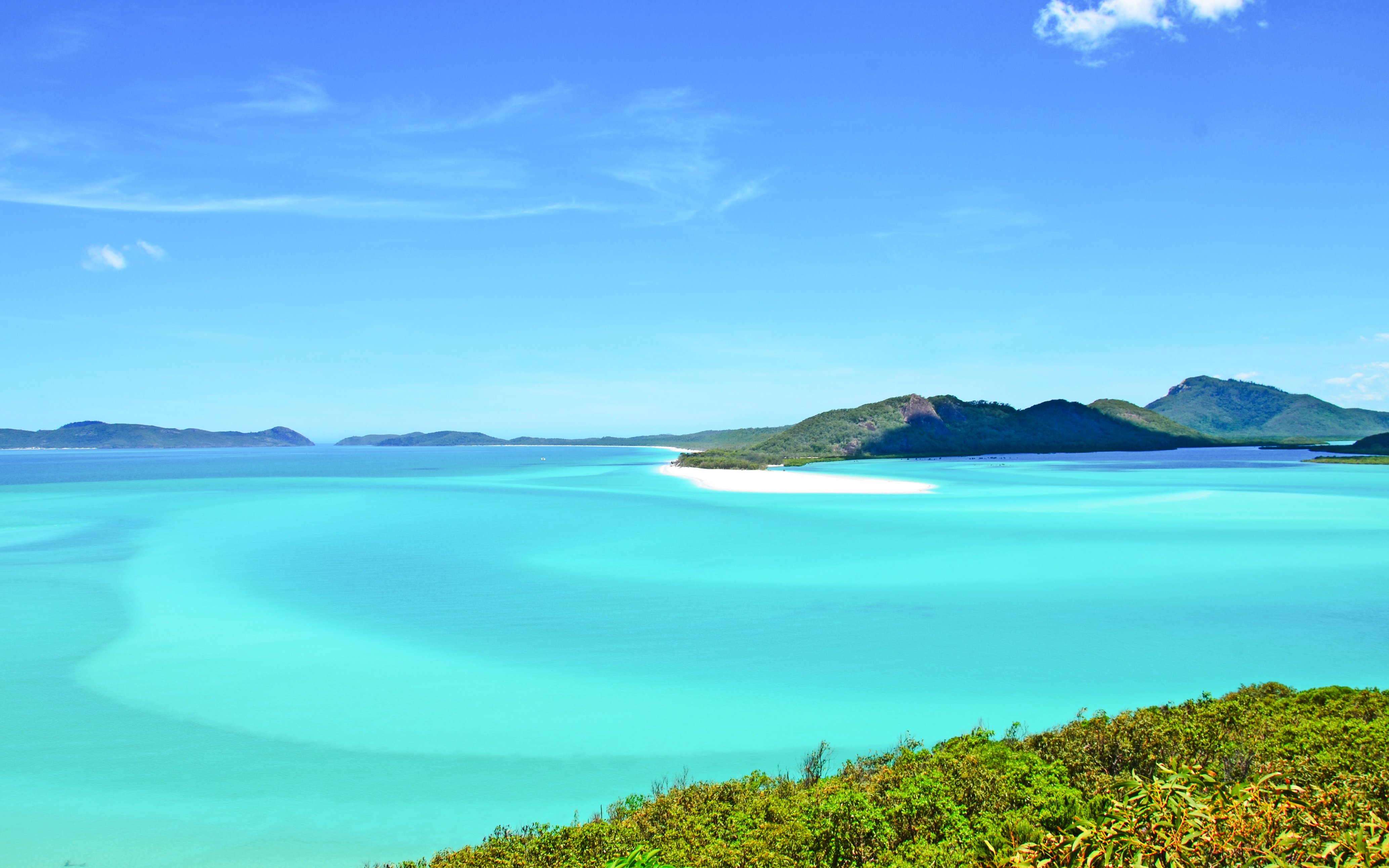 Clear turquoise water and lush islands of The Whitsundays, Australia.